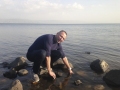 Normunds smeļ ūdeni no Galilejas jūras Tabgā